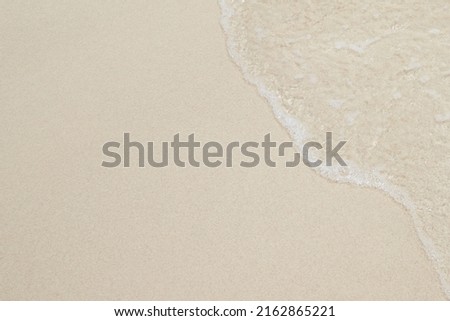 Close Up soft wave flow beautiful ocean on sandy beach. Background. sunshine in the evening. top view.
