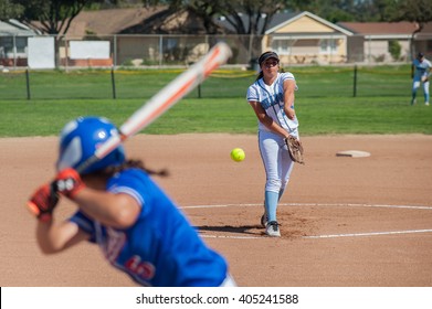 Close Up Of Softball Pitcher Throwing The Curve Ball To The Batter. 