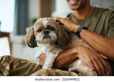 Close up of soldier cuddling his dog while relaxing at home. Dog is looking at camera. - Powered by Shutterstock