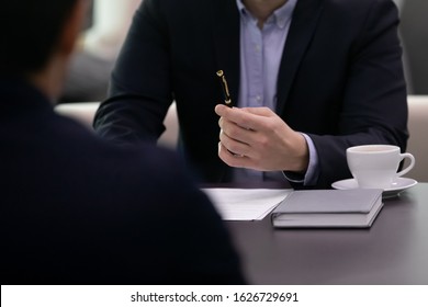 Close Up Solicitor Lawyer Real Estate Agent Holding Pen, Ready Signing Contract With Client, Sitting Together At Table. Confident Businessman Offering Putting Signature To Partnership Agreement.