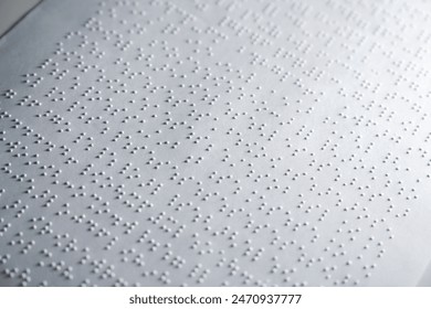 Close up some braille text on page paper written by blind. Blind man using slate and stylus tools making embossed printing the braille alphabet Code on sheet. - Powered by Shutterstock