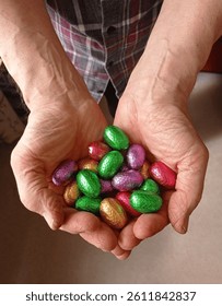 Close up of some chocolate Easter eggs in a person's hands.