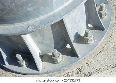 Close up of some larger screws into the base of a metal pillar.