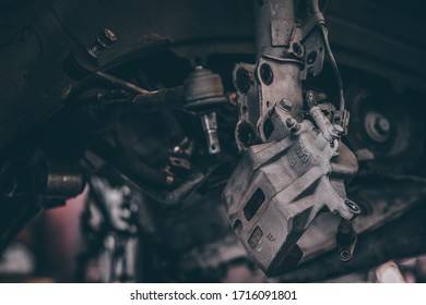 Close up some part from car engine in car garage which removed from engine for fix or repair. Dark tone.  Selective focus.