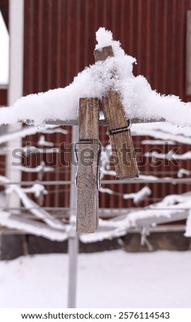 Close up of some snow covered clothes pins on a clothes line in january.