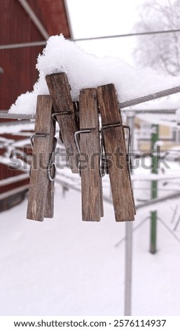 Close up of some snow covered clothes pins on a clothes line in january.
