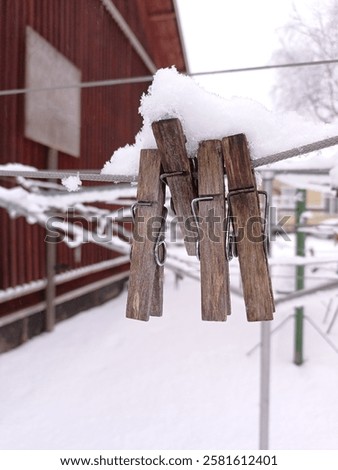 Close up of some snow covered clothes pins on a clothes line in january.