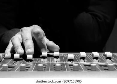 close up sound engineer hands adjusting control surface mixer in recording, broadcasting studio