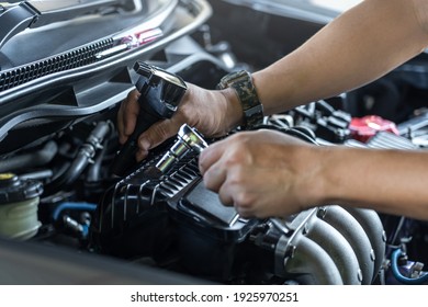 Close Up Spark Plug Coil On Engine Cover And A Man Use Block Wrench Remove A Bolt For Take Off Coil Engine Service In Garage And Engine Room  Background