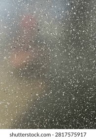 Close up of speckled granite surface texture with subtle light flare reflection
