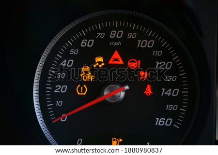 Close up of speedometer dial with warning lights on a car