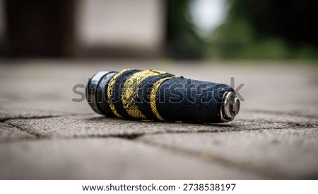 A close up of a spent and discarded pyrotechnic firework shell lying on the ground after a holiday party or event.