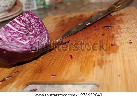 close up of split red cabbage with butchers knife on a cutting board