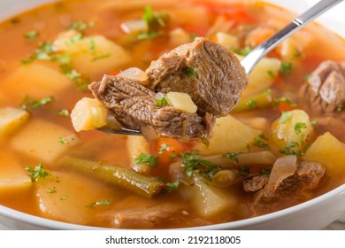 Close Up Of Spoon Filled With Vegetable Beef Soup 