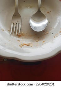 Close Up Of Spoon And Fork On A Dirty White Plate