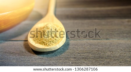 Close up of spoon with Kava Kava root powder in wooden cup