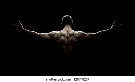 Close up of sports man's muscular back isolated on black background - Powered by Shutterstock