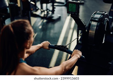 Close up of sportswoman exercising on rowing machine in gym. - Powered by Shutterstock