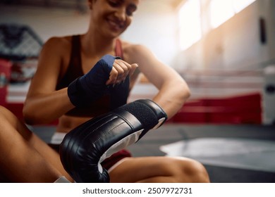 Close up of sportswoman using boxing gloves during sports training in health club.  - Powered by Shutterstock