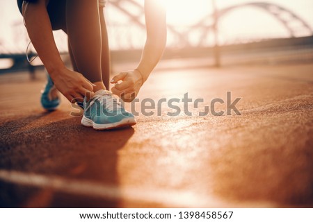 Close up of sporty caucasian woman kneeling and tying shoelace on court in the morning. Sometimes the best runs come on days you didn’t feel like running.