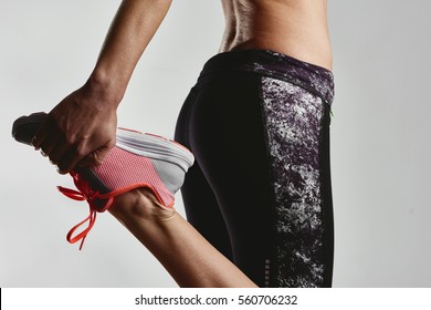 Close up of sporty female stretching legs muscles before run. Jogging and fitness concept. 