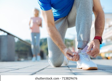 Close up of sporty senior man tying shoelaces on sneaker - Powered by Shutterstock