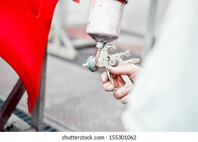 Close Up Of Spray Gun Painting A Car 