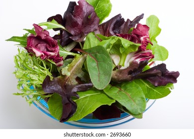 Close Up Of Spring Mix Organic Salad Over White Paper