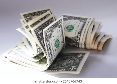 Close up of a stack of bent US one dollar bills isolated on a white background. US currency.