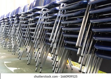 Close up stack of chairs outside classroom. Focus at chair legs.