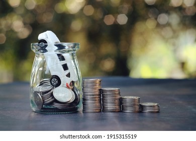 close up stack of coin, glass bottle with toy car and money on table, saving and manage for success transport, transportation insurance technology, economic crisis risk and problem concept