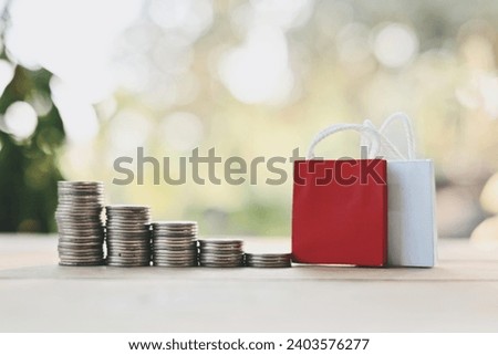 close up stack of coin and small shopping bag on wood table, saving and manage money for holiday season, merry Christmas and happy new year, Boxing Day sale concept