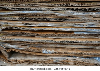 close up stack of containerboard sheets or old brown box paper recycle in warehouse facility