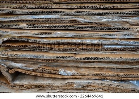 close up stack of containerboard sheets or old brown box paper recycle in warehouse facility