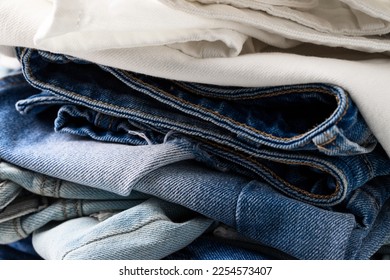 Close up of Stack of different colors jeans texture. Shop, sale cocnept.