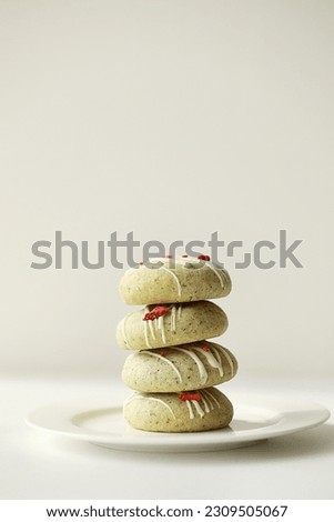 Close up of stack of homemade mint gingerbread cookies with matcha, decorated sublimated strawberries and vanilla cream on plate on white background. Sugar, gluten and lactose free and vegan