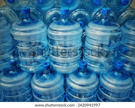 Close up of a stack of many empty water bottles, refillable water jugs.