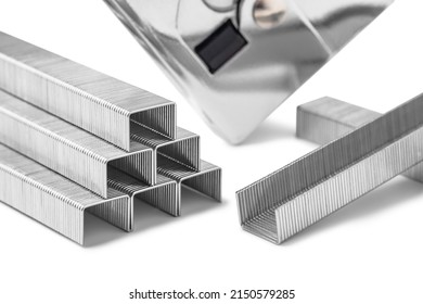Close up of stack of metal staples for stapler gun isolated on white background, selective focus. Industrial tool.