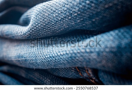 Close up of stack of old jeans various shades of blue jeans. Denim jeans texture. Denim background texture for design. Canvas denim texture. Blue denim background.