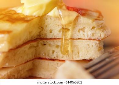 close up Stack of pancakes in syrup and butter dessert on dish at wood table. selective focus