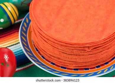 Close up of stack of red corn tortillas on a traditional mexican table runner.