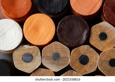Close up of a Stack of unsharpened pencils and fleshtone crayons, writing instruments