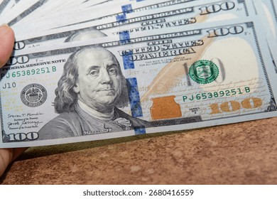Close up of a stack of US one hundred dollar banknotes. Concept of finance money wealth savings investment and banking background