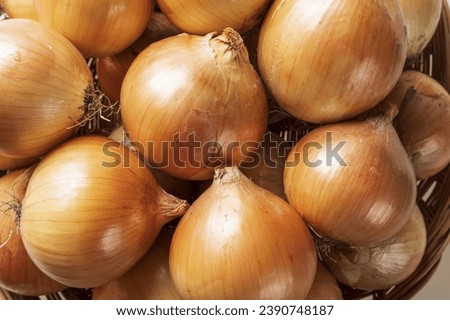 Close up of stacked raw onion with skins on bamboo basket, South Korea
