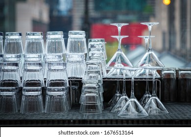 Close Up Of Stacked Shot Glasses And Martini Glasses Against A Window.