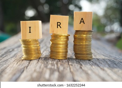 Close up of stacking gold coins and wooden blocks written IRA on nature background and natural lighting. Individual Retirement Accout concept  - Shutterstock ID 1632252244