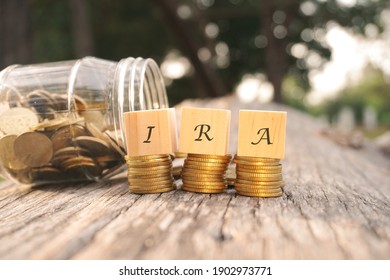 Close up of stacking gold coins and wooden blocks with words IRA on nature background. Individual Retirement Account Concept.  - Shutterstock ID 1902973771