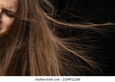 Close up of static long hair standing on end, on black background.