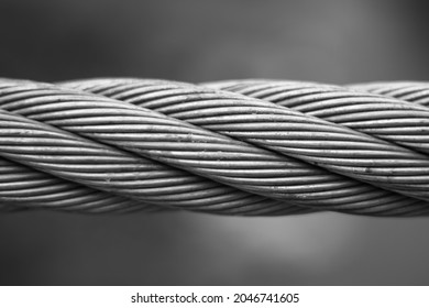 Close up steel cable that connects the suspension bridge on the river Ribnica in black and white.