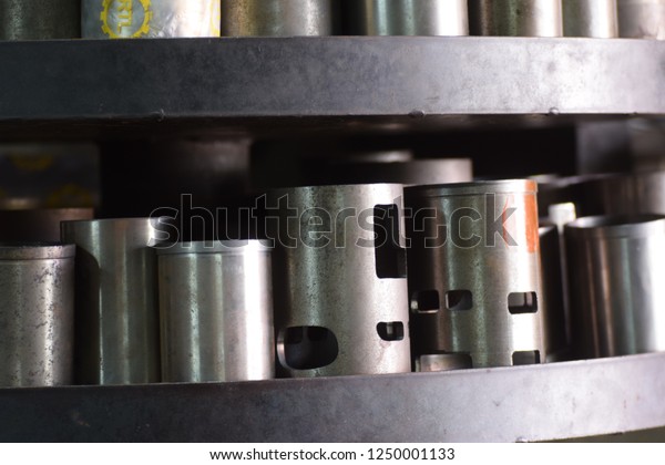 close up to steel\
cylinder pistons were kept on shelves with some of them had holes\
but some of them were\
not.